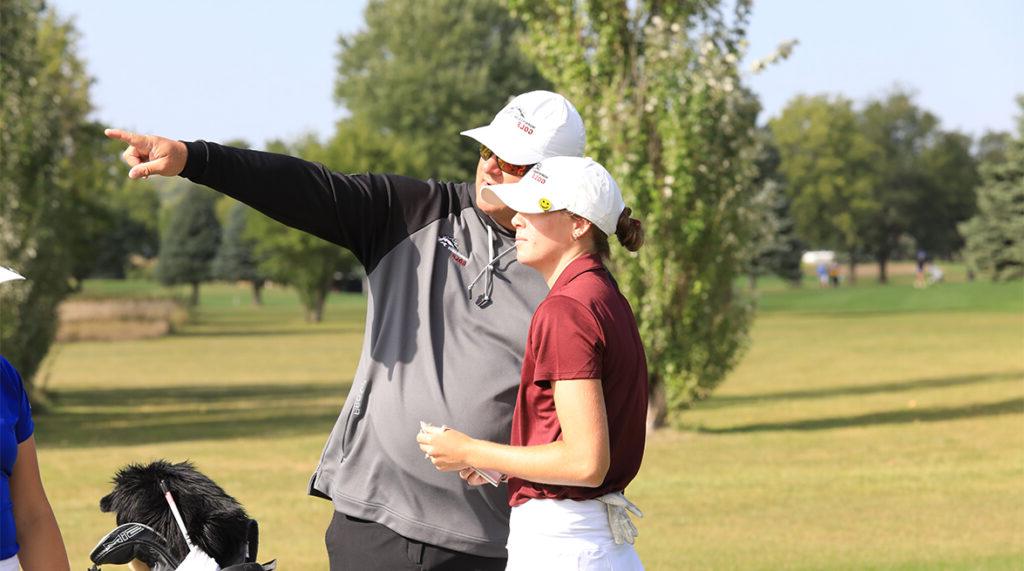 365体育的高尔夫教练在开球前给球员指点.